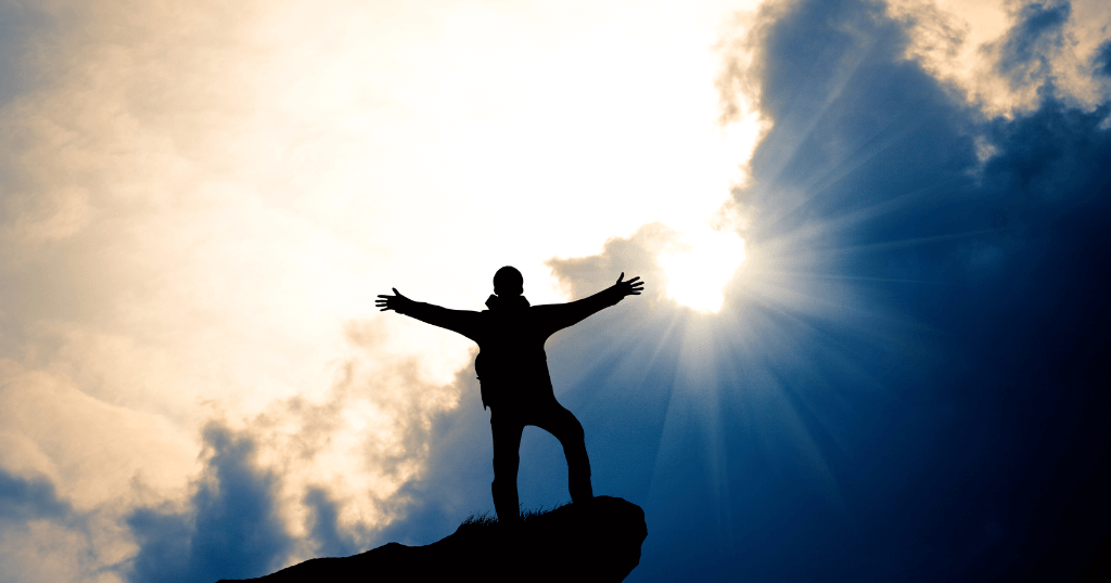 Man on Cliff with Dark Clouds Celebrating Freedom