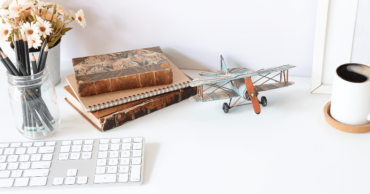 White Desk With Keyboard Books and Model Airplane