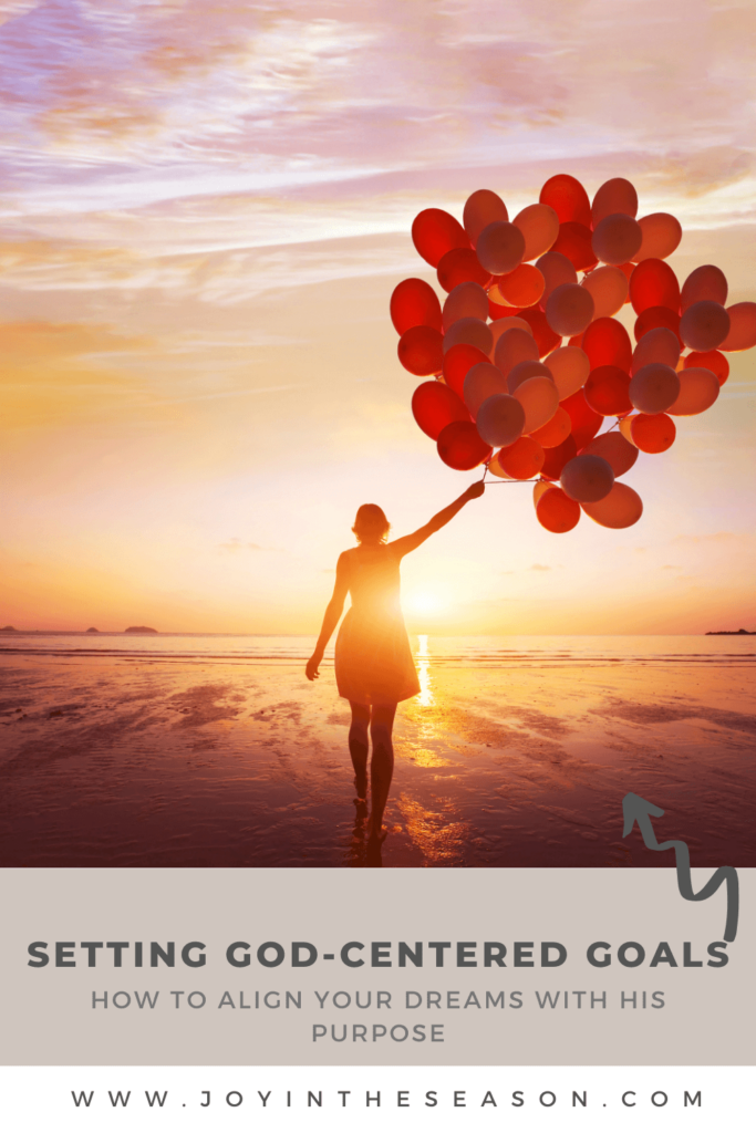 Woman walking into sunset with red balloons