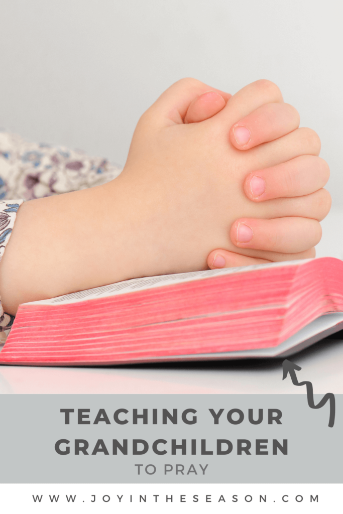 Child’s Hands Folded In Prayer On Bible