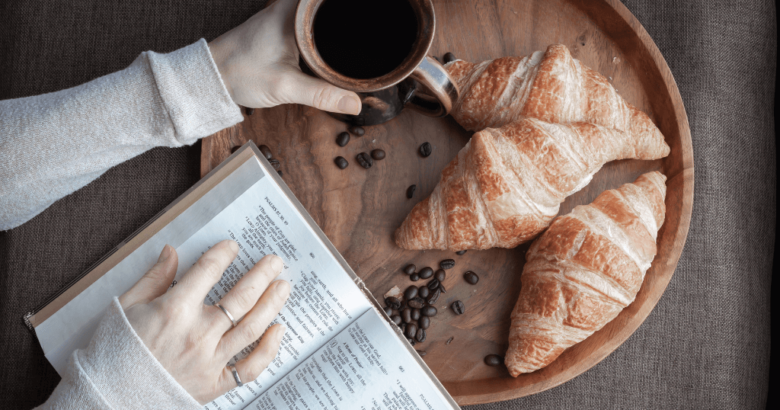 Woman reading Bible with coffee and croissants